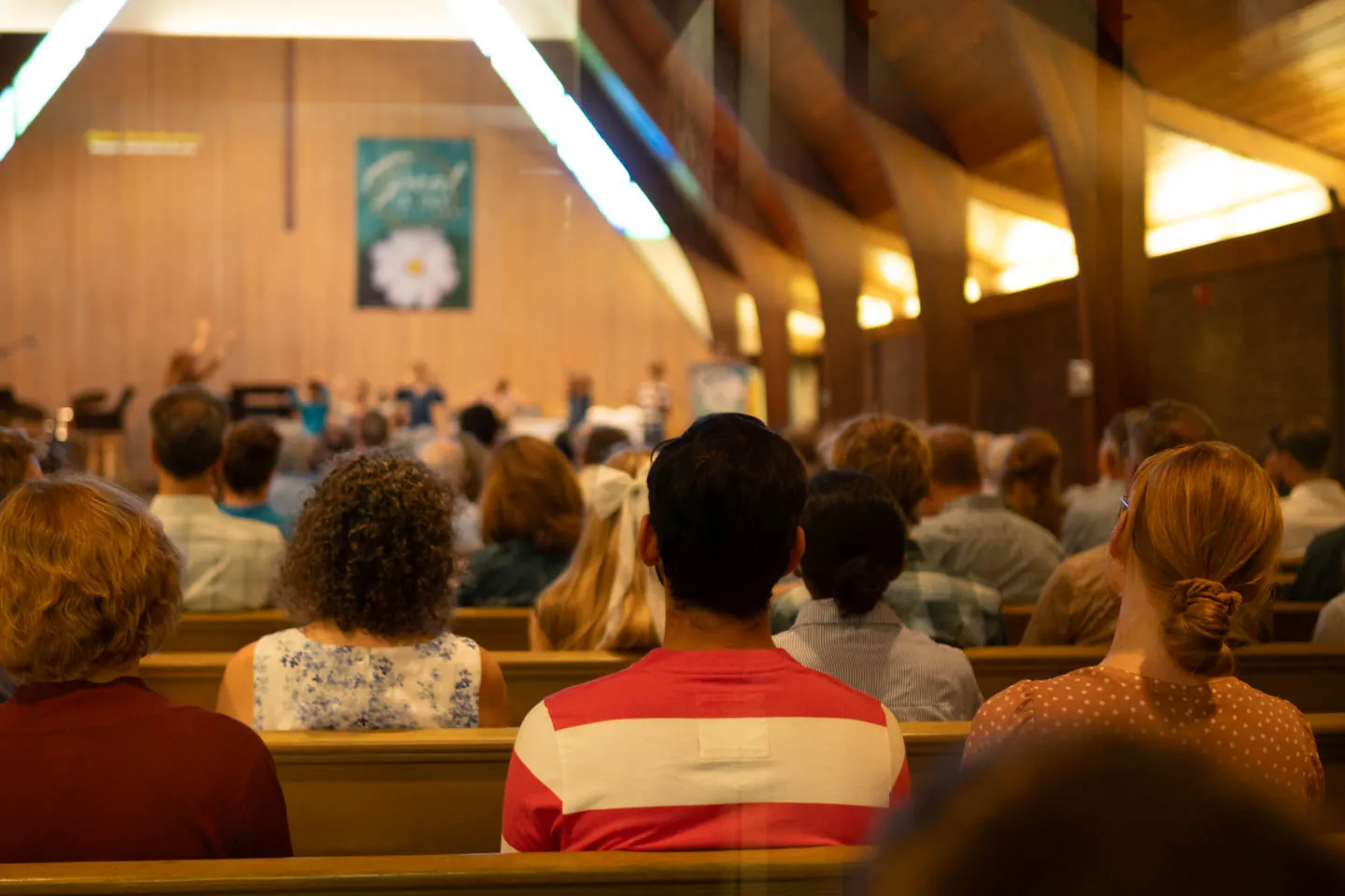 The Ann Arbor Christian Reformed Church congregation seated in its sanctuary during a service, seen from the back of the room