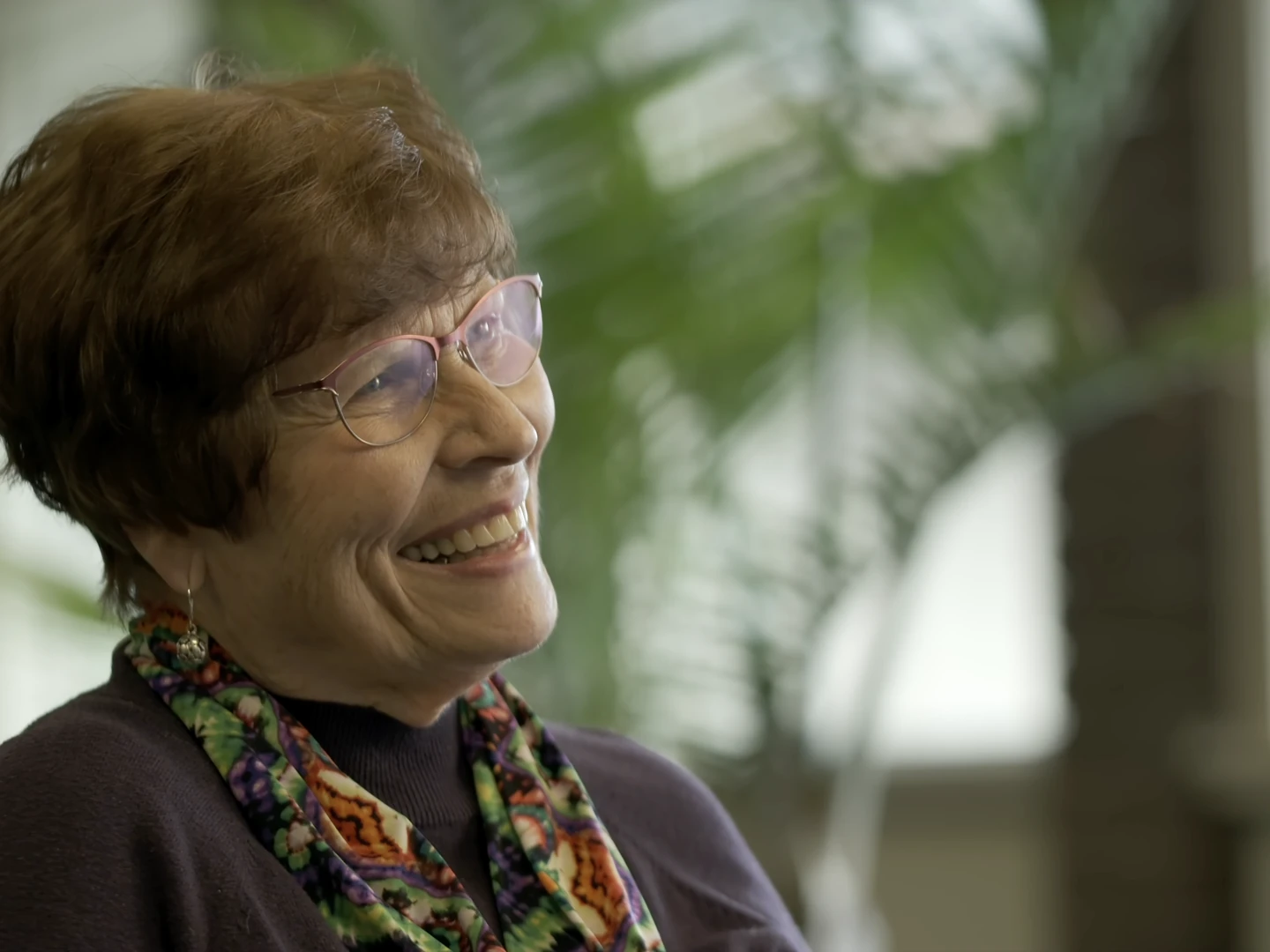 A community member laughing during an interview — a still from the One Another documentary