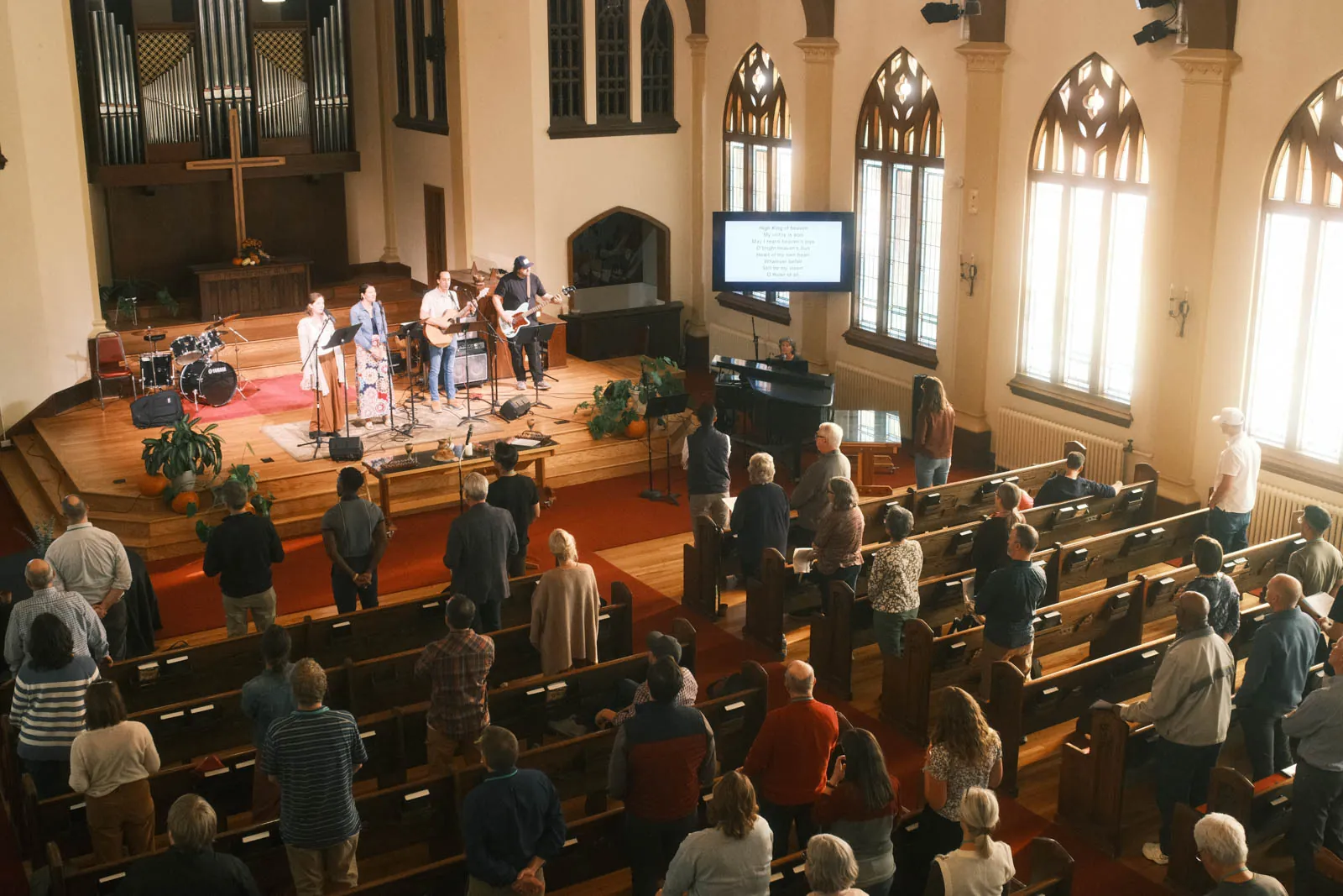 A congregation at worship in a historic sanctuary, seen from the balcony